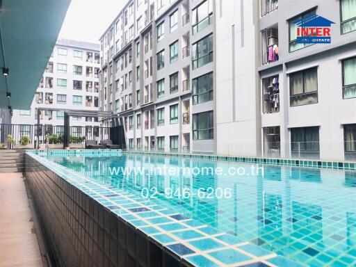 Outdoor view of residential apartment complex featuring a swimming pool