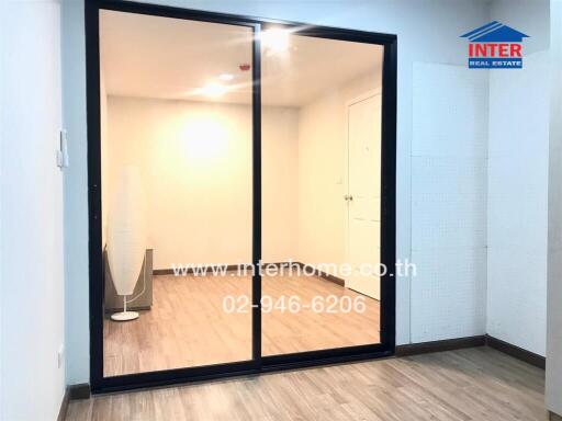 Spacious living room with wooden flooring and glass sliding door