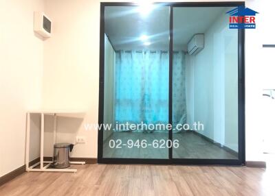 Living area with wooden floor, sliding glass door, and a small table