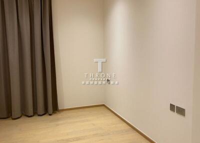 Empty bedroom with wooden floor and window with curtains
