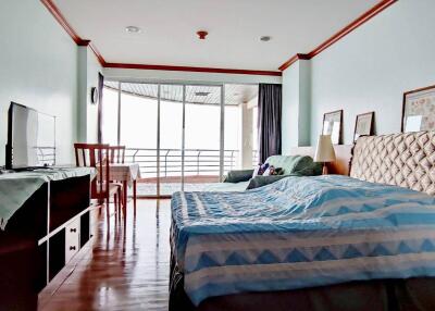 Spacious bedroom with balcony and wooden flooring