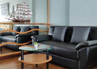 Living room with black leather sofa and glass coffee table