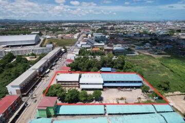 Aerial view of a property with surrounding buildings and landscape