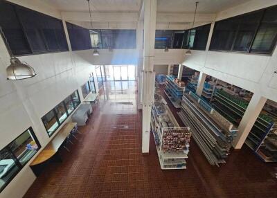 Interior view of a spacious commercial building with high ceilings and tiled flooring