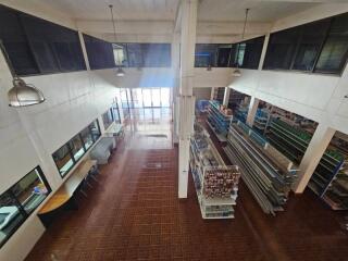 Interior view of a spacious commercial building with high ceilings and tiled flooring