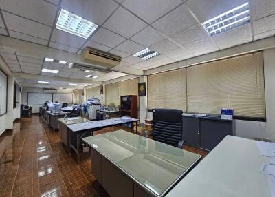 Spacious office area with multiple desks, chairs, and office equipment