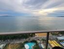 Scenic view from the balcony over the ocean and surrounding area with a pool and buildings