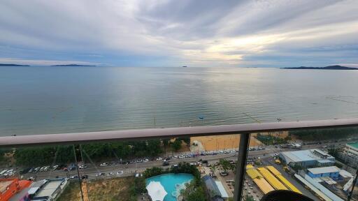 Scenic view from the balcony over the ocean and surrounding area with a pool and buildings