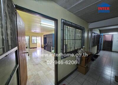 Entryway and hallway leading to living area with visible furnishings