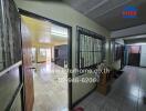 Entryway and hallway leading to living area with visible furnishings