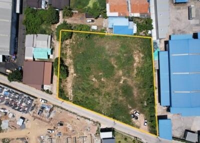 Aerial view of a vacant lot bordered in yellow, surrounded by buildings and a road.