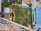 Aerial view of a vacant lot bordered in yellow, surrounded by buildings and a road.