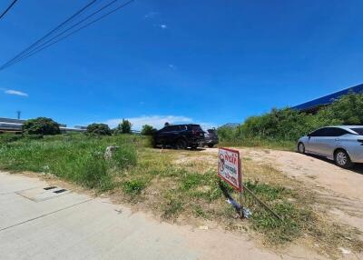 Vacant land with vehicles parked on it under a clear blue sky