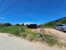 Vacant land with vehicles parked on it under a clear blue sky