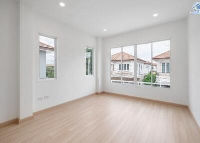 Empty bedroom with large windows and wooden floor