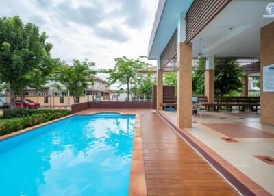 Outdoor swimming pool area with a covered seating space