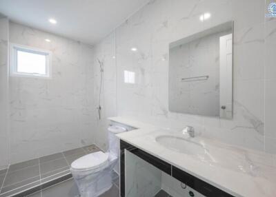 Modern bathroom with large mirror, sink, toilet, and walk-in shower