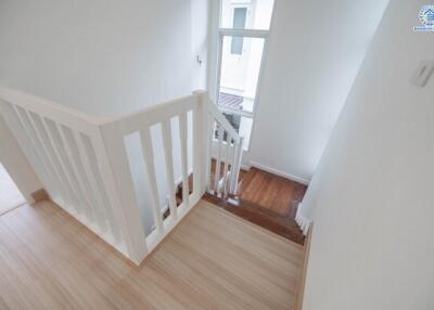 Bright staircase with wooden steps and white railing