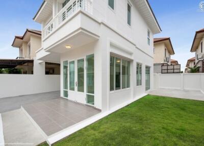 Modern white two-story house with a small yard and patio