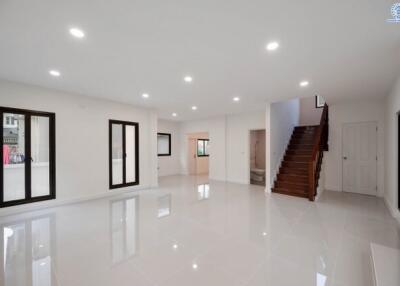 Spacious living area with stairs and large windows