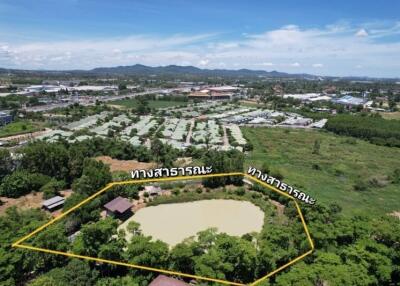 Aerial view of a property with a pond and surrounding greenery