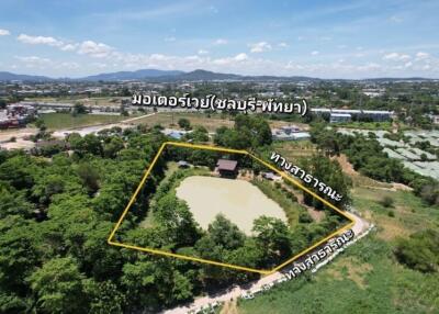 Aerial view of a property with a pond and surrounding greenery