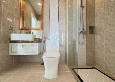 Modern bathroom with glass shower, toilet, and basin