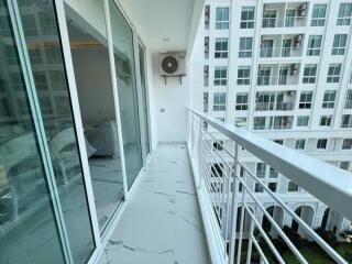 Modern apartment balcony with glass doors and view of adjacent building
