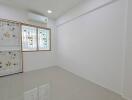 Small empty bedroom with tiled floor and decorated window grills