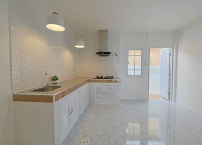 Modern kitchen with white cabinets and wooden countertop