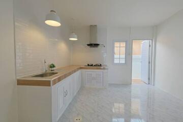 Modern kitchen with white cabinets and wooden countertop