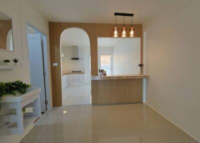 Modern minimalist living space with partial view of a kitchen