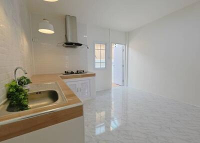 Modern kitchen with marble flooring and wooden countertops