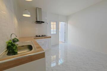 Modern kitchen with marble flooring and wooden countertops