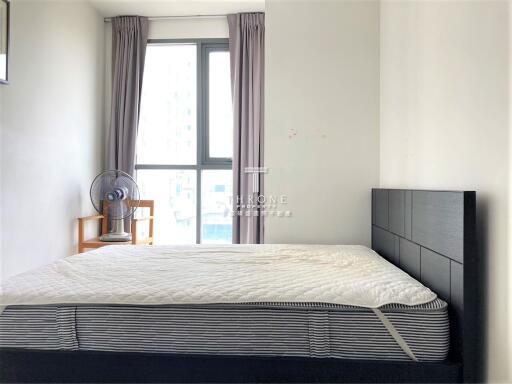 Bedroom with large window and simple furnishings