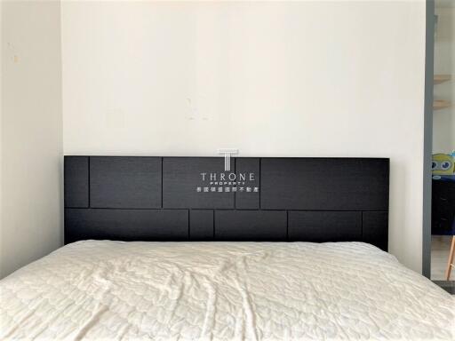 Modern bedroom with a bed featuring a black headboard