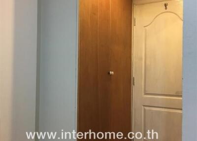 Hallway with wooden closet and white door