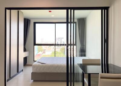 Modern bedroom with glass sliding doors and city view