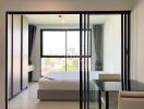 Modern bedroom with glass sliding doors and city view