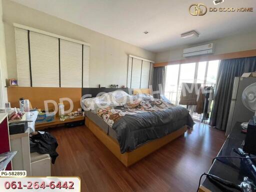 Spacious bedroom with large bed and wooden flooring