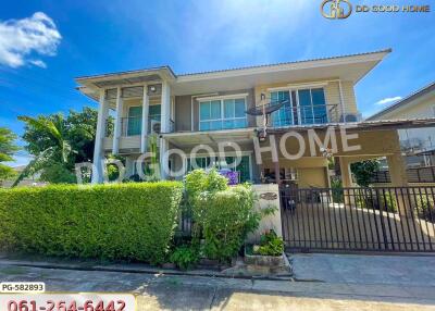 Exterior view of a modern two-story house with a gated entrance