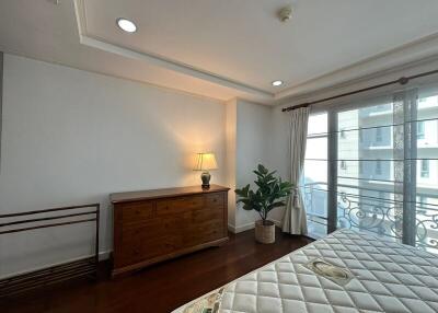 bedroom with wooden dresser and large window