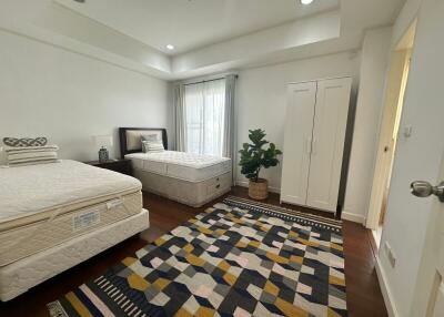 Spacious bedroom with two twin beds, wardrobe, and window