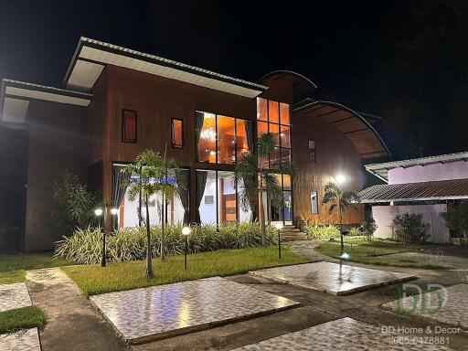 Exterior view of a large modern home with extensive lighting