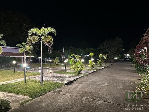 Outdoor area with parking and pathway illuminated at night