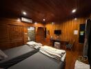 Spacious wooden-clad bedroom with twin beds and a desk area