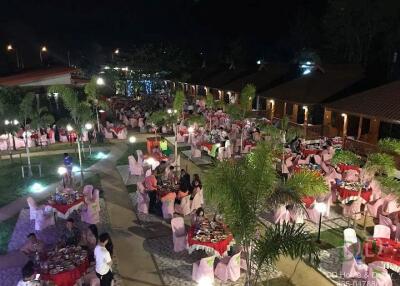 Outdoor dining area with tables and chairs set up for an event at night