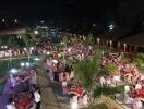 Outdoor dining area with tables and chairs set up for an event at night