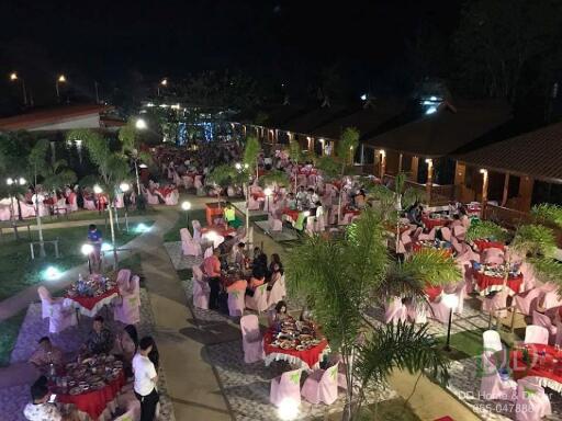 Outdoor dining area with tables and chairs set up for an event at night