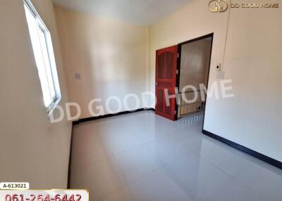 Empty bedroom with window and red door